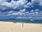 Paradise Beach with Yacht passing Sandy Island.